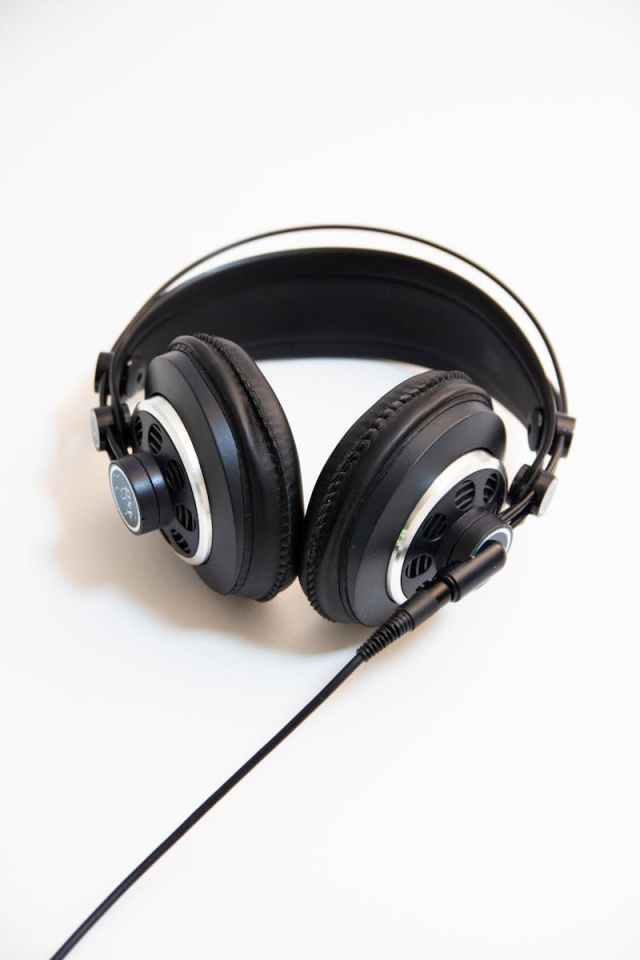 Close-up of black over-ear headphones with cable on a clean white background.