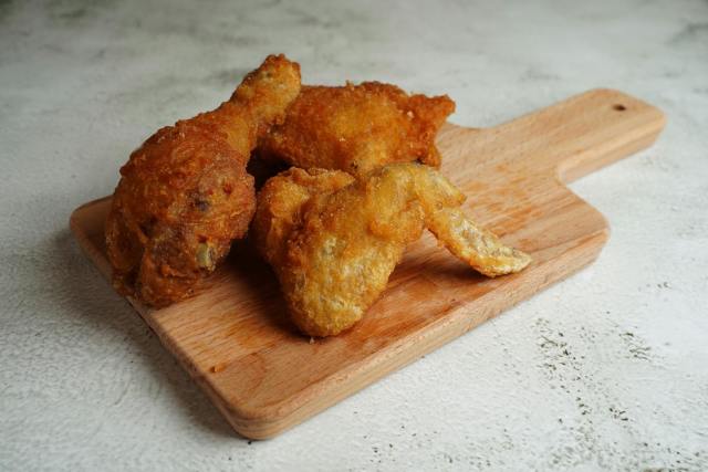 Delicious crispy fried chicken pieces served on a wooden cutting board.