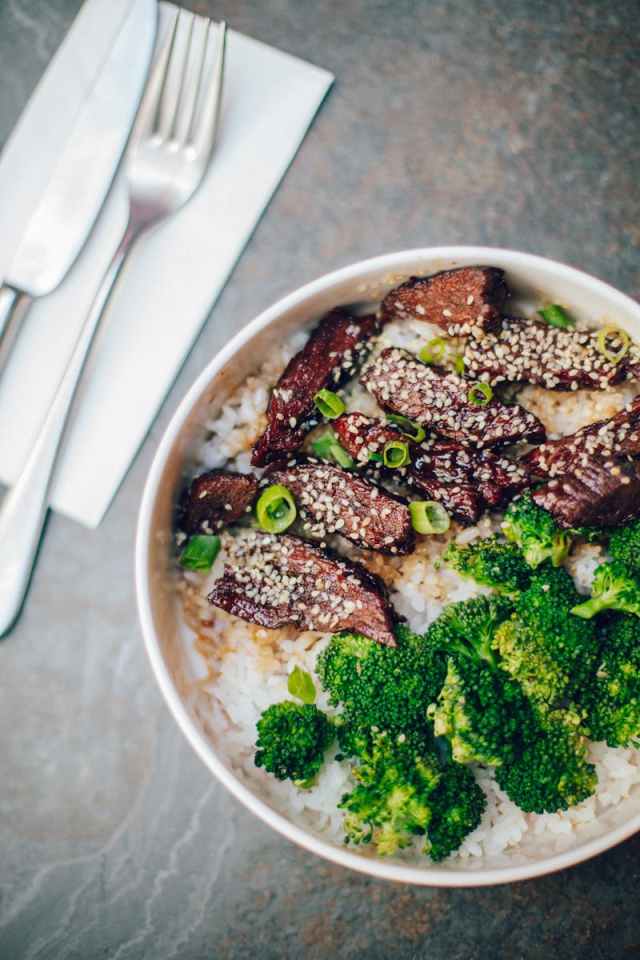 Delicious beef and broccoli served on rice with sesame seeds, top view.