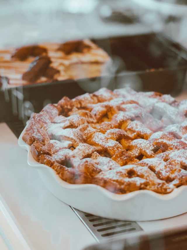 Warm homemade apple pie with powdered sugar, perfect for a cozy dessert treat.