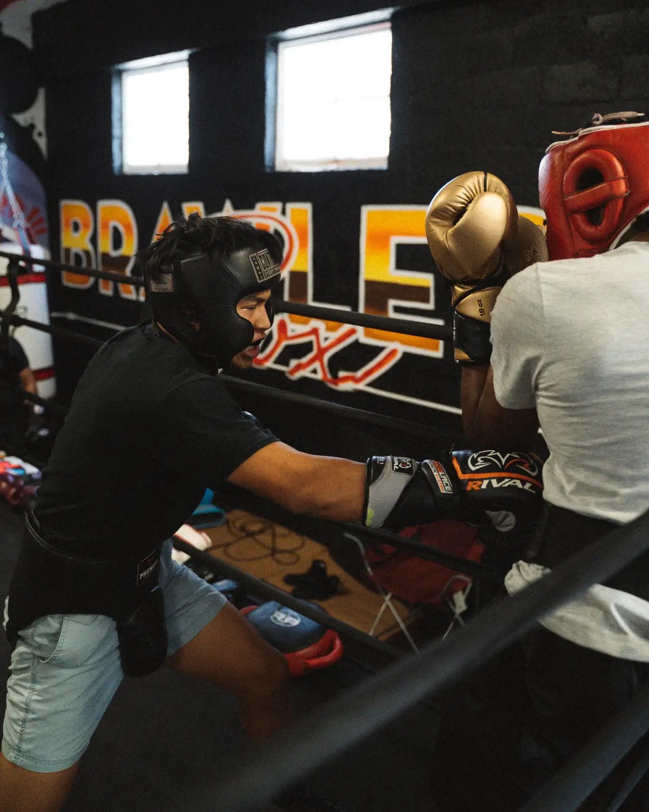 Boxer in gold gloves throwing a punch against the ropes