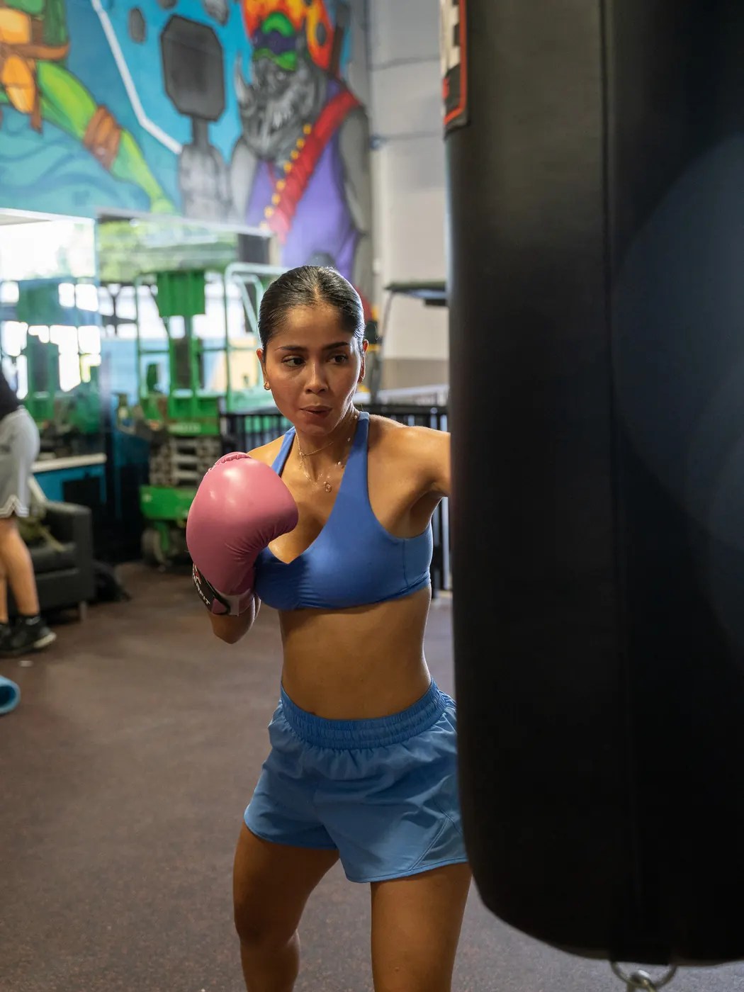 Member working the heavy bag in boxing gloves