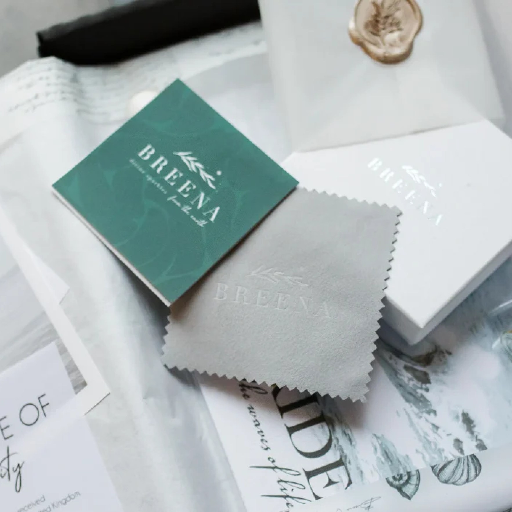 A photo showcasing the perfect gift from Breena Jewellery, including polishing cloth, sea glass jewellery, info card and many more.