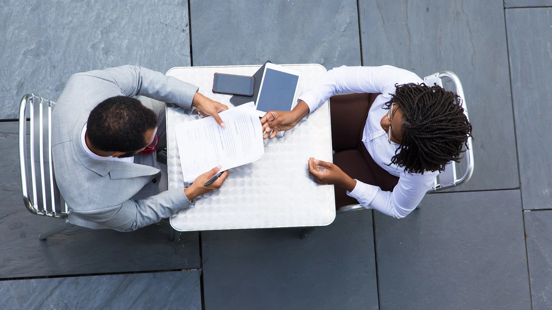 Business professionals signing documents at a meeting table