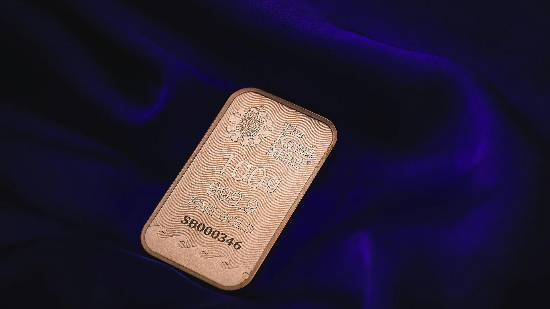 Gold bar with engraving "The Royal Mint 100g Fine Gold 999.9," symbolizing liquidating hard assets.