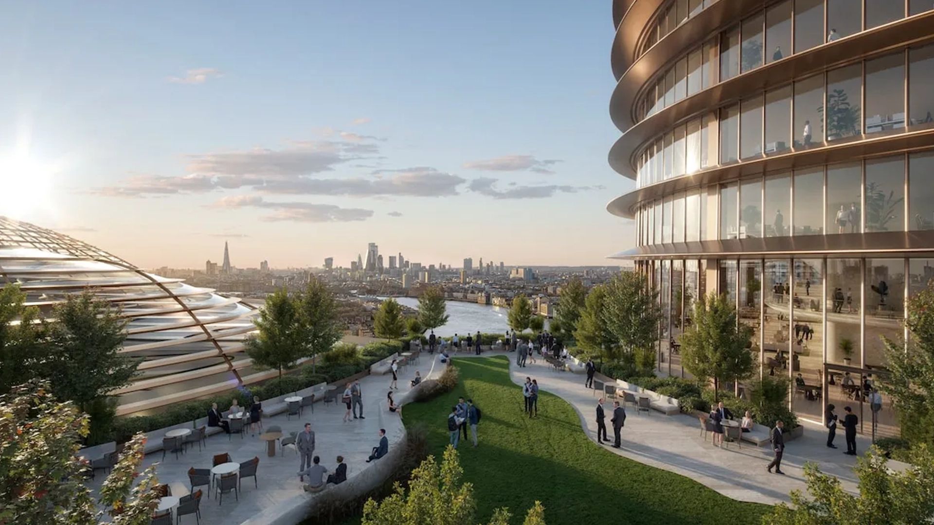 A contemporary riverside development featuring curved glass buildings landscaped terraces and people socialising in an elevated public space overlooking a city skyline at sunset