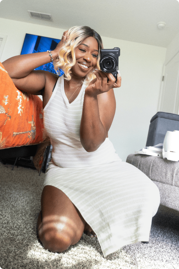Mary holding a camera taking her picture in front of the mirror