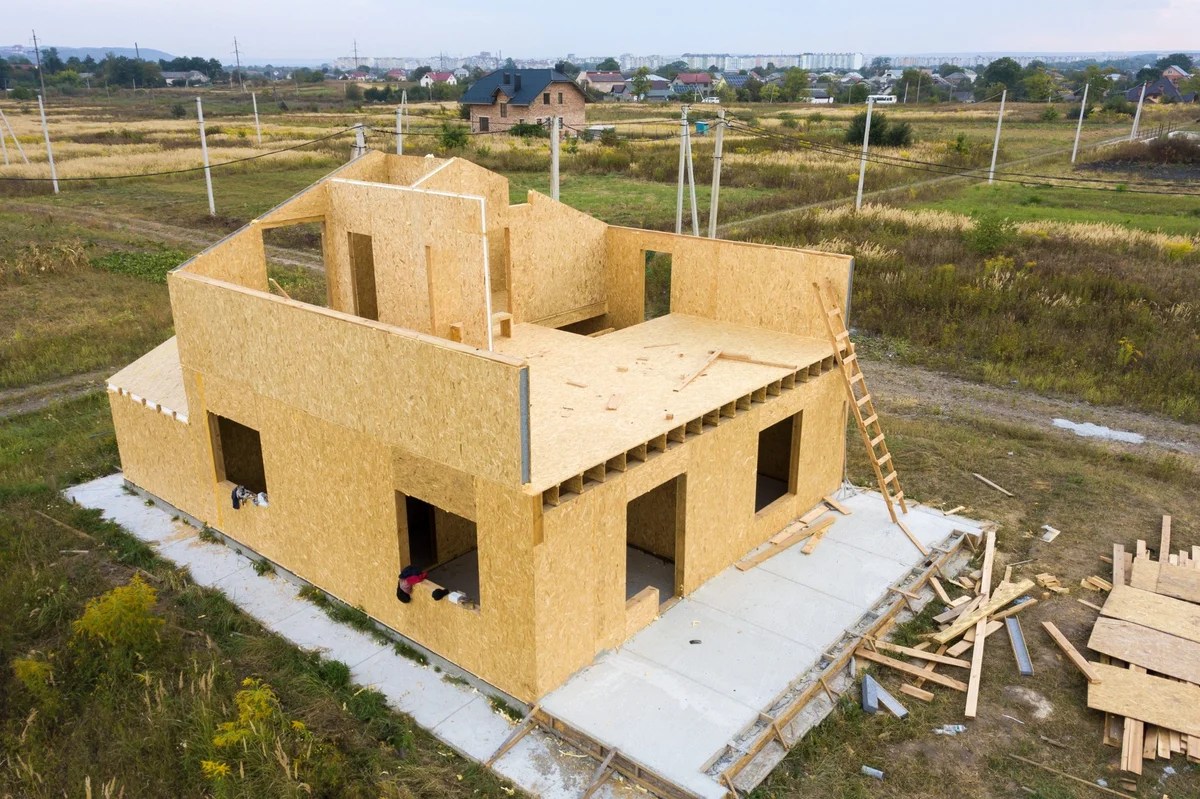 Wooden modular home under construction in rural residential area”