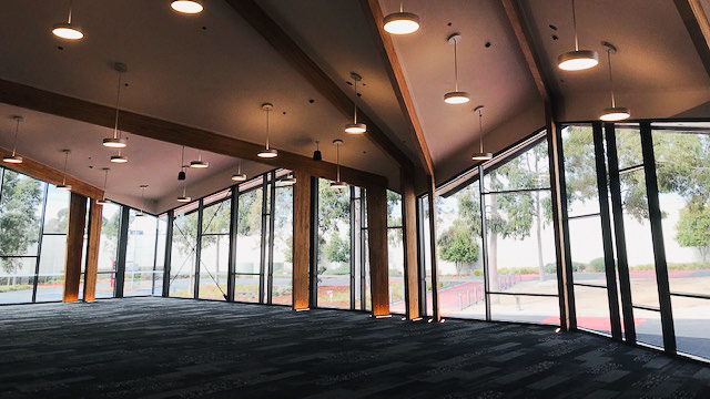 Large carpeted room at the Melbourne Showgrounds with large windows and many lights
