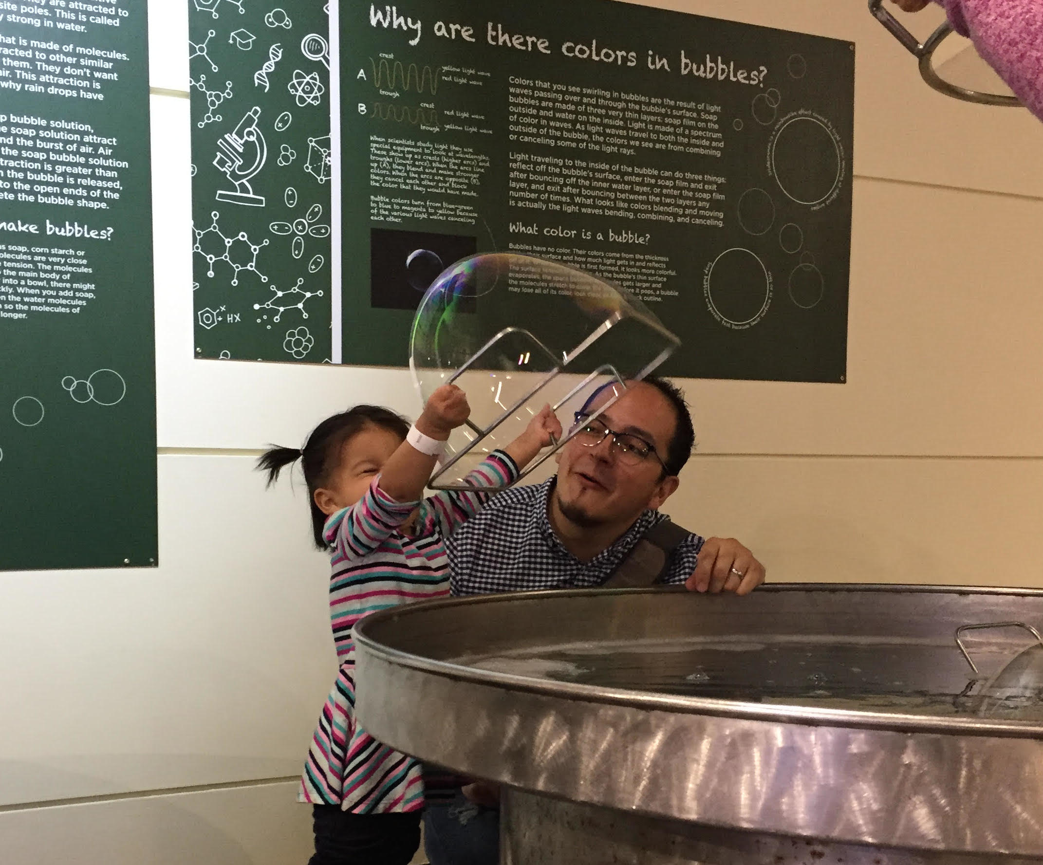 A little girl blowing a huge bubble.
