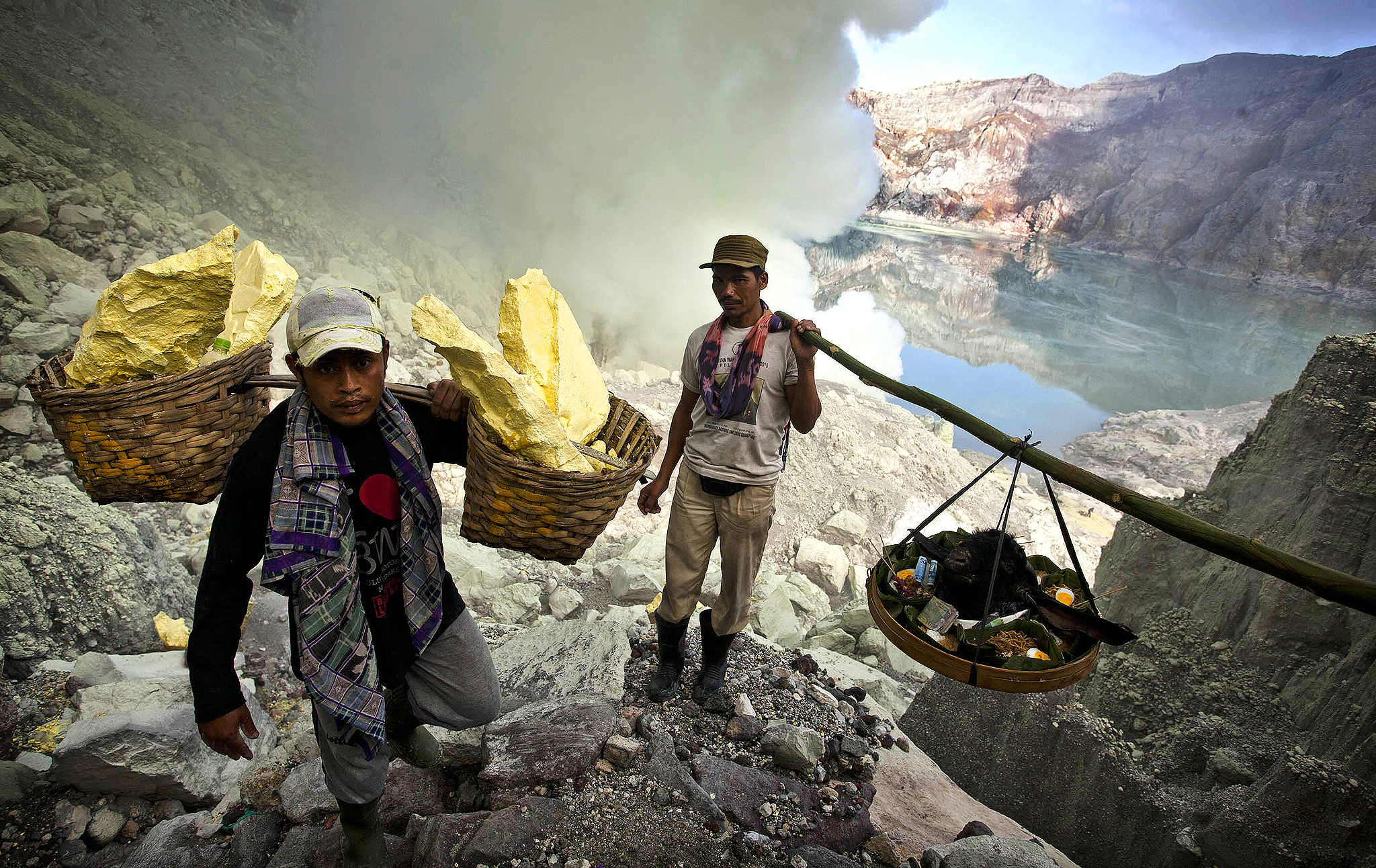 Indonesian Sulfur Miners Make Offering To Protect Against Disaster...BANYUWANGI, EAST JAVA - DECEMBER 17: Miners carry a goats head for burial in the crater as part of an annual offering ceremony on the Ijen volcano on December 17, 2013 in Yogyakarta, Indonesia. The ritual is performed by the sulfur miners of Mount Ijen who slaughter a goat and then bury the head in the crater of mount Ijenn. The sacrifice is performed to ward off potential disasters for the next year. The Ijen crater rises to 2,386m, with a depth of over 175m, making it one of the world's largest craters. Sulphur mining is a major industry in the region, made possible by an active vent at the edge of a lake, but the work is not without risks as the acidity of the water in the crater is high enough to dissolve clothing and cause breathing problems. (Photo by Ulet Ifansasti/Getty Images)