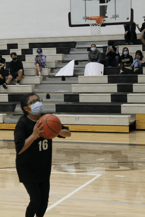 Michelle Tzompa prepares to shoot with her family cheering her on in the stands (sign). Photo: TCSD