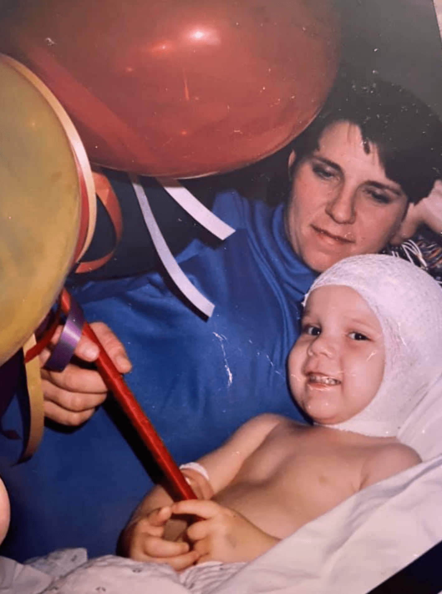 Baby Ben in the hospital with Heather, holding balloons