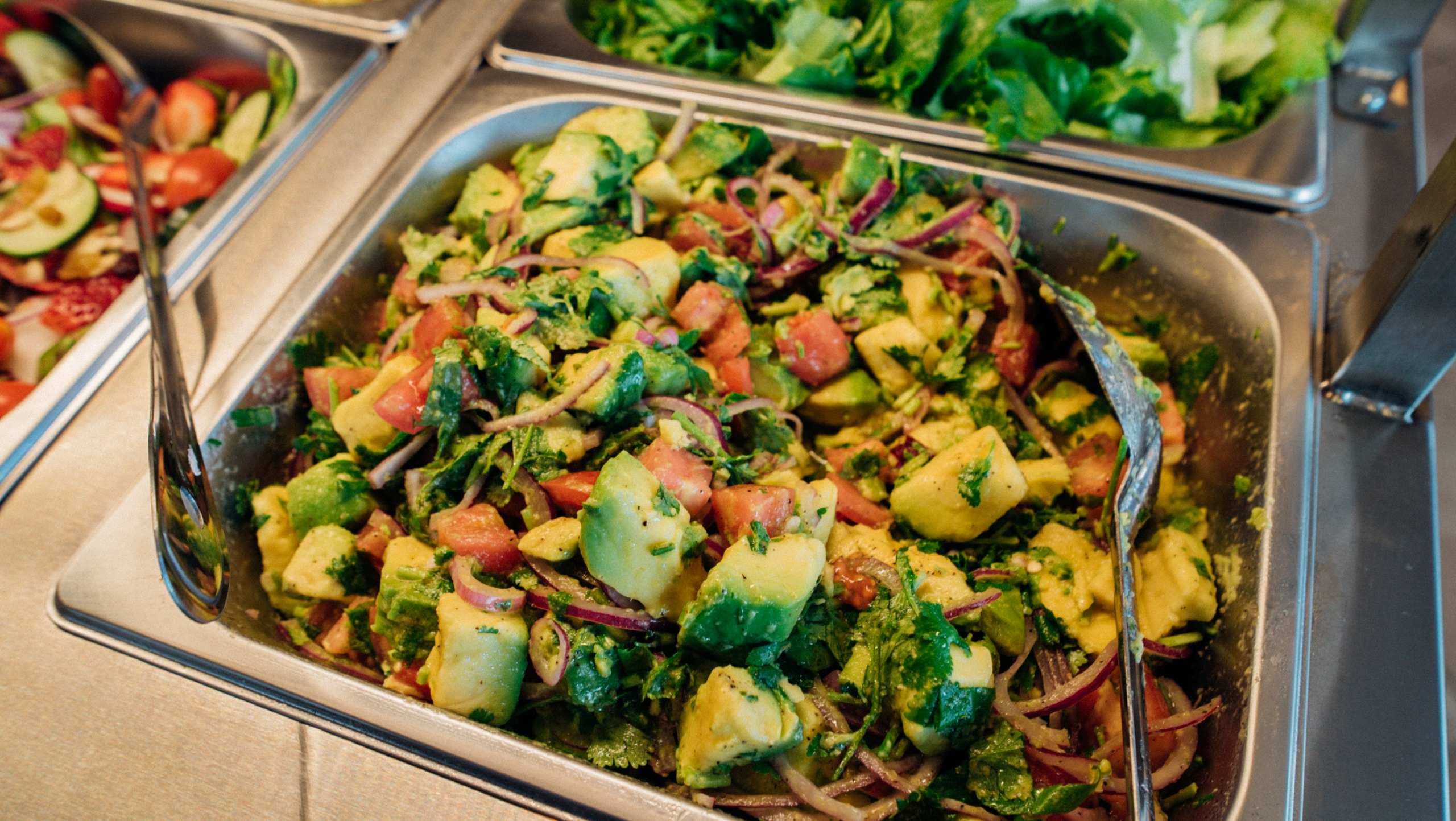 Ensalada fresca de aguacate con tomate y cebolla en buffet