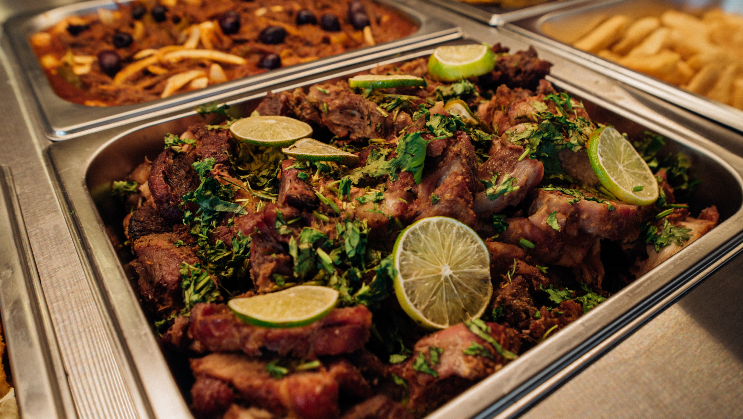 Cerdo dorado con limón y cilantro servido en buffet caliente