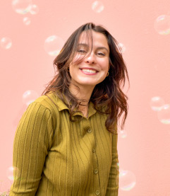 Portrait souriant d'une fondatrice de Bulle Wedding Planner sur fond rose à motif de bulles