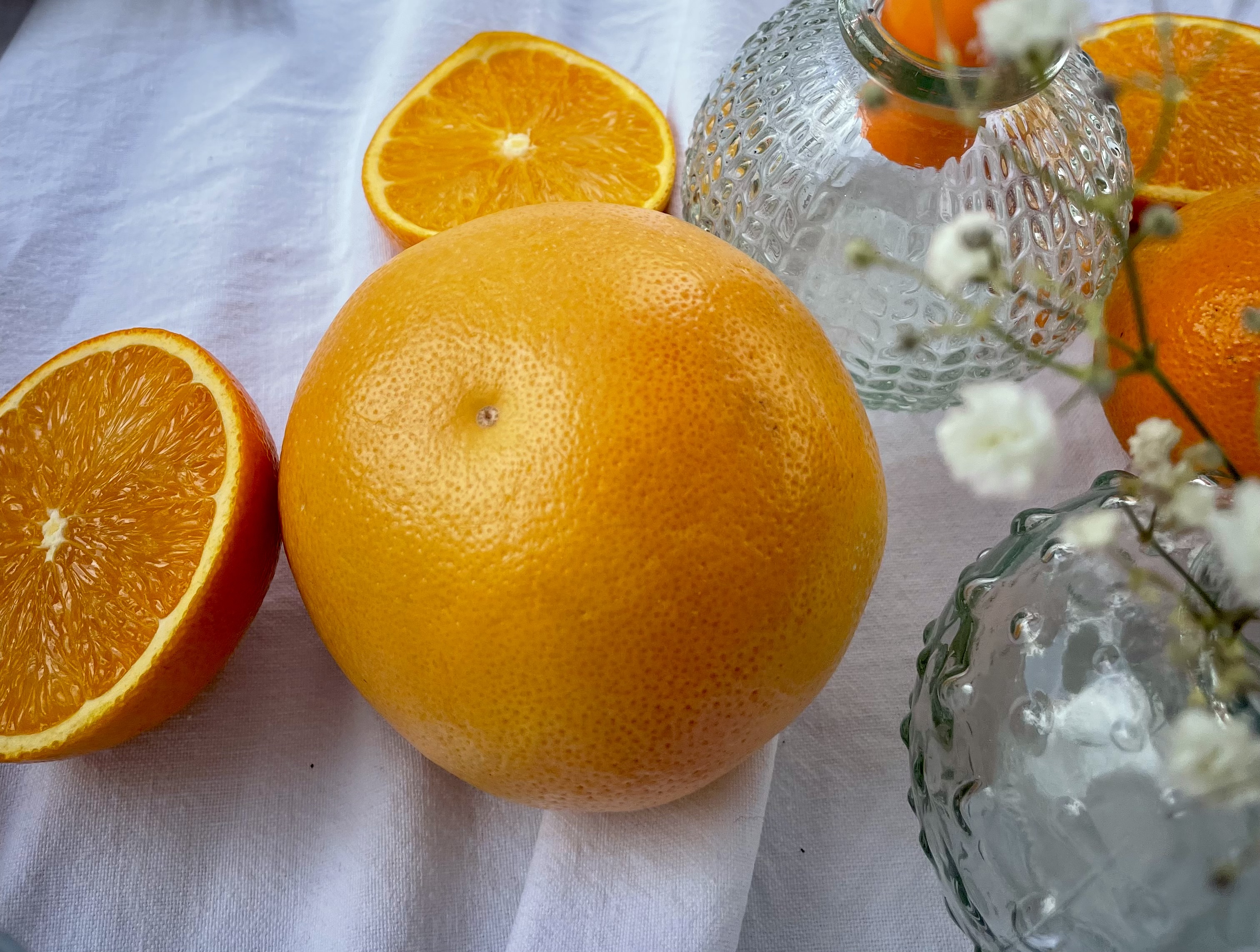 Agrumes coupés et petites fleurs blanches en décoration de table