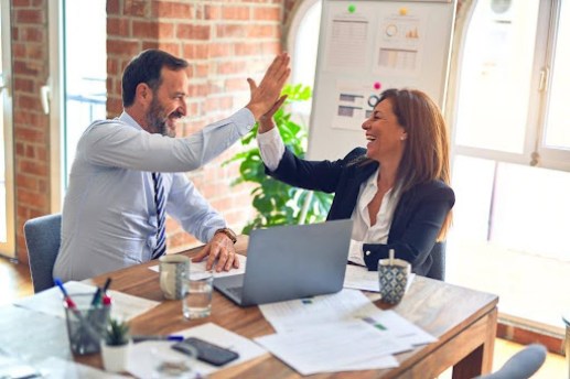 Business professionals high-fiving after finalizing what is AI enterprise search implementation strategy