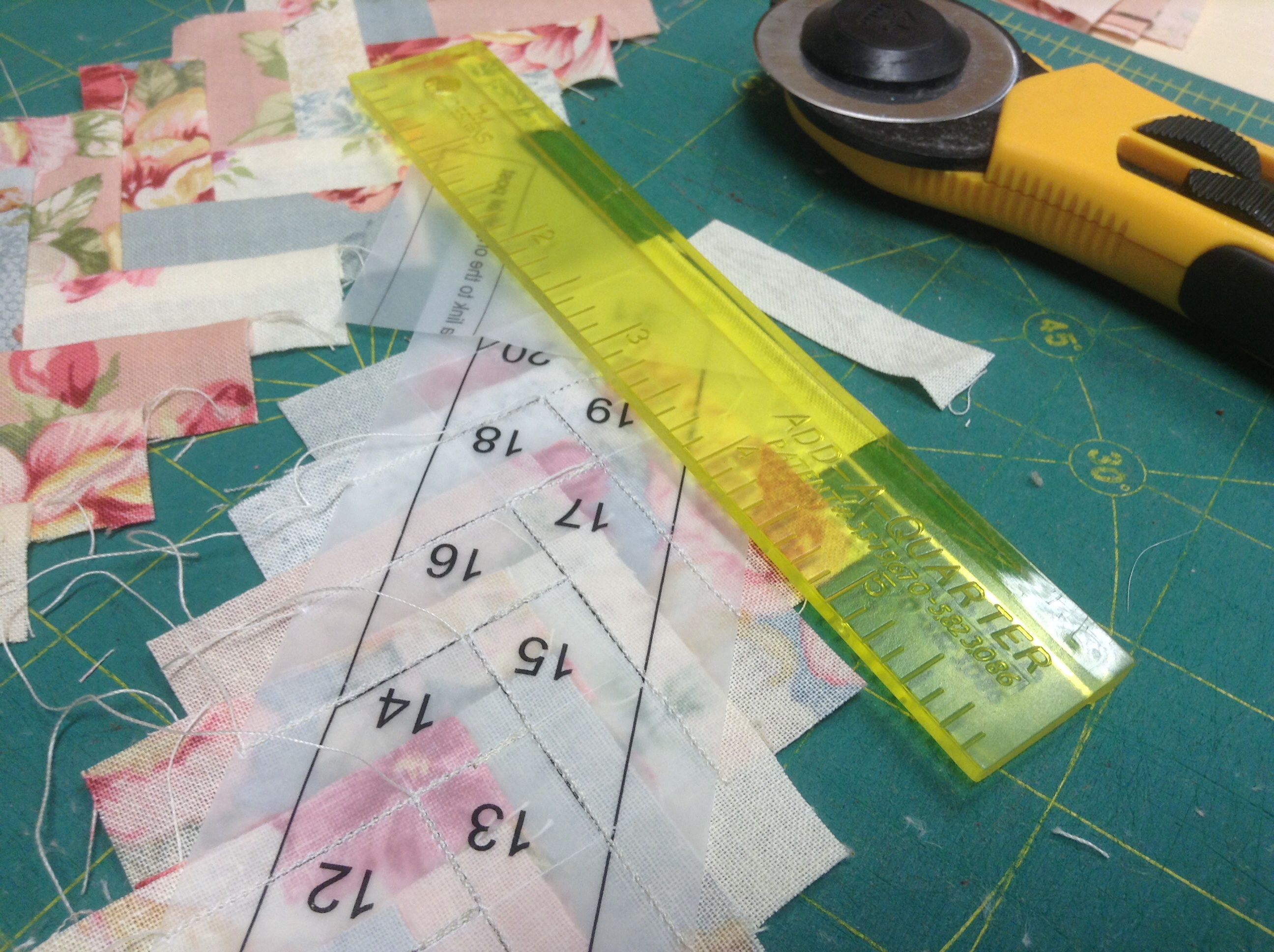 Trimming the seam allowance using a quarter inch ruler.