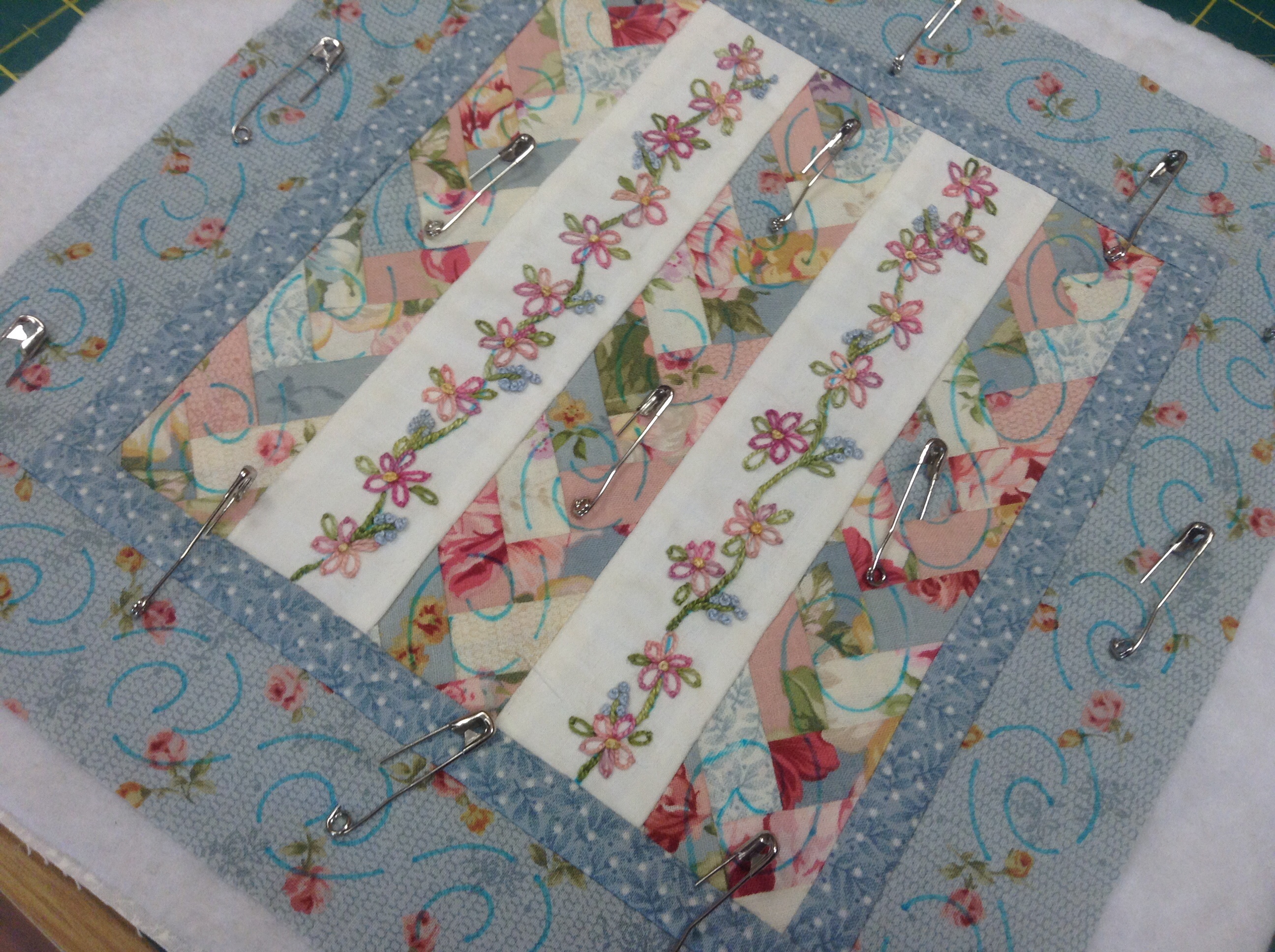 Marking the quilting design and sandwiching the quilt using safety pins.