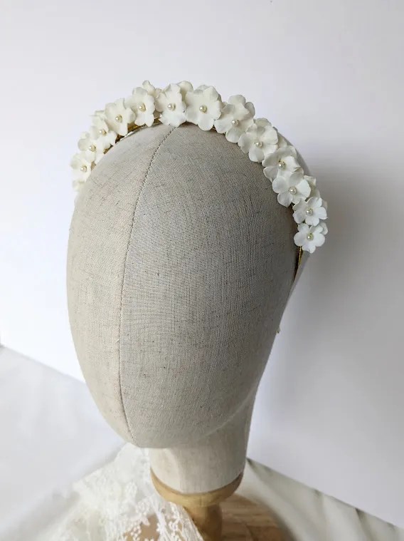 Couronne de fleurs coiffure mariage Mathilde. Petites fleurs blanches de porcelaine et perles nacrées.