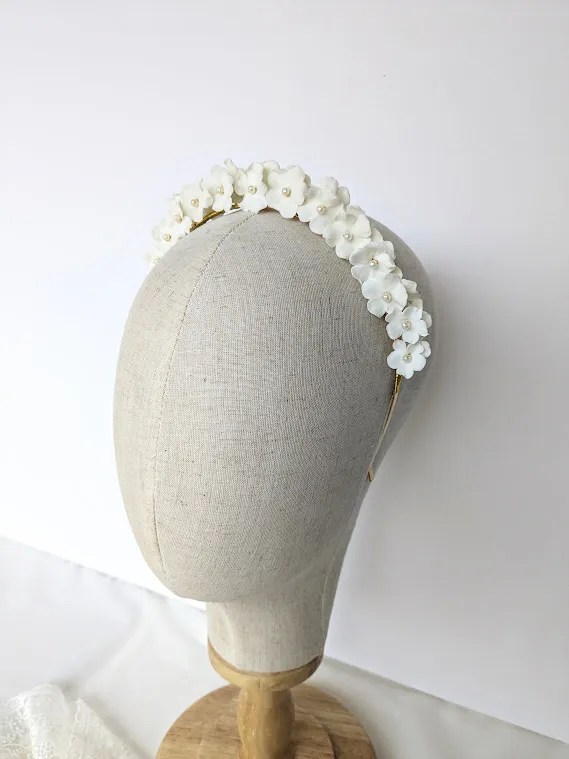 Couronne de fleurs coiffure mariage Mathilde. Petites fleurs blanches de porcelaine et perles nacrées.