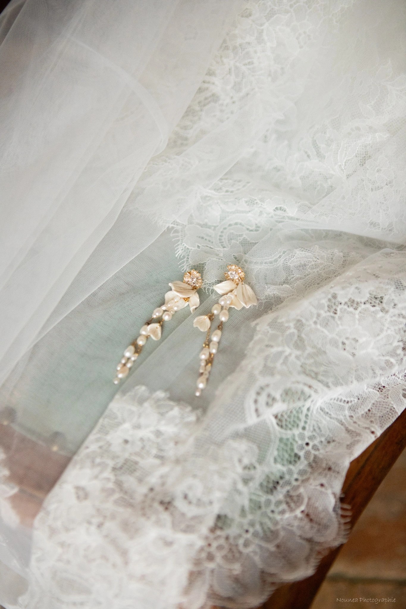 Boucles d'oreilles ADÉLAÏDE posées sur un voile de dentelle : pétales de porcelaine froide nacrée, by Marguerite