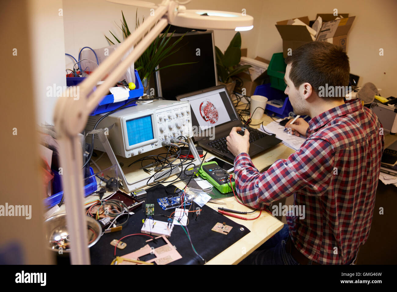 Electrical Engineer Testing Component At Work Bench Stock