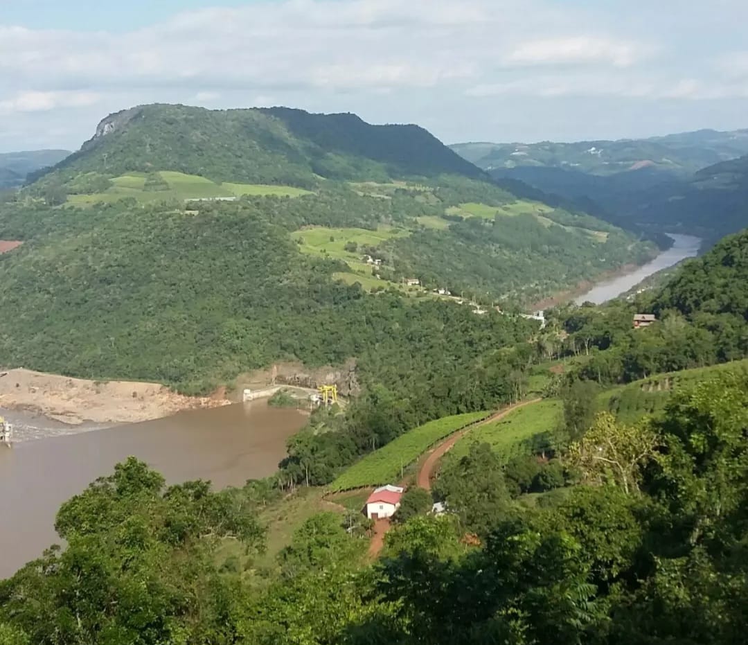 Vista aérea de vale com rio e mata nativa, área de atuação da CAGR no Rio Grande do Sul