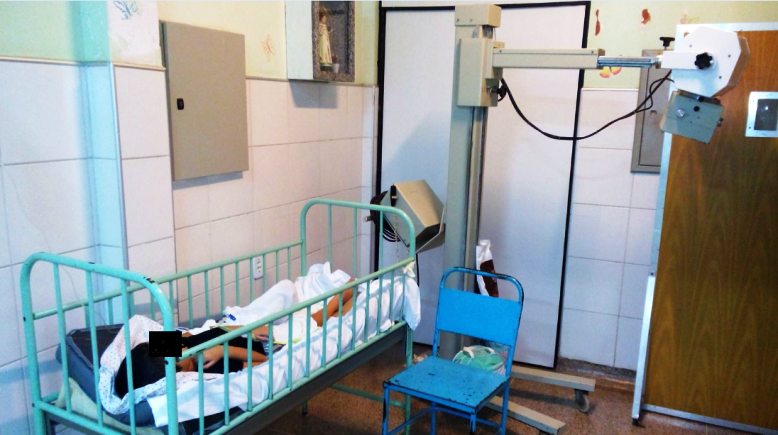 Paciente no corredor embaixo de um aparelho de Raio X, além das péssimas condições dos móveis e aparelhos, cuja infecção prolifera!!!