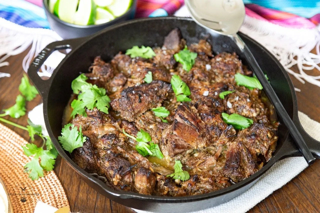 Shredded Mexican Beef Barbacoa in a cast iron garnished with cilantro