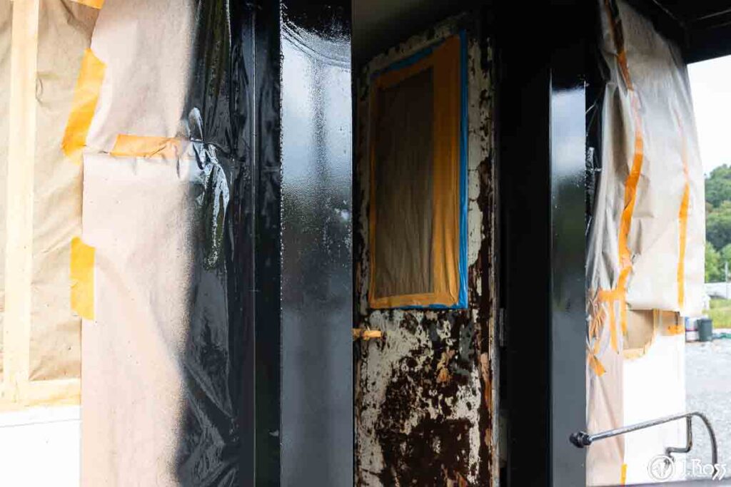 Close-up of gloss black Sherwin-Williams Industrial Enamel Alkyd freshly sprayed on caboose door frame during restoration
