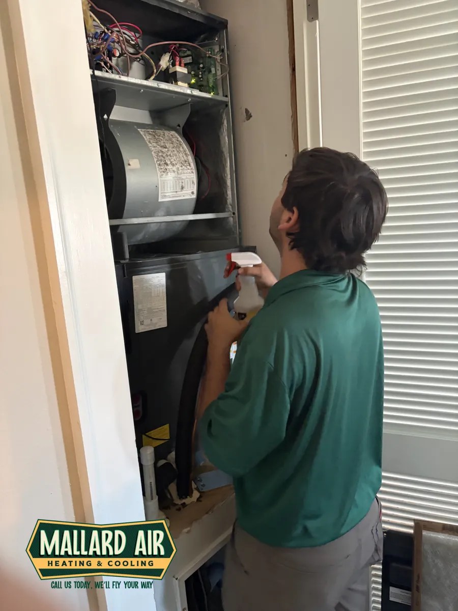 Mallard Air technician cleaning an air handler during a fall tune-up in Baldwin County