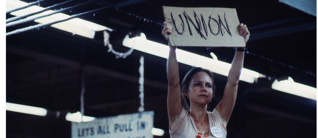An iconic still of Sally Field holding up a sign that says "UNION" in the 1979 film, Norma Rae.
