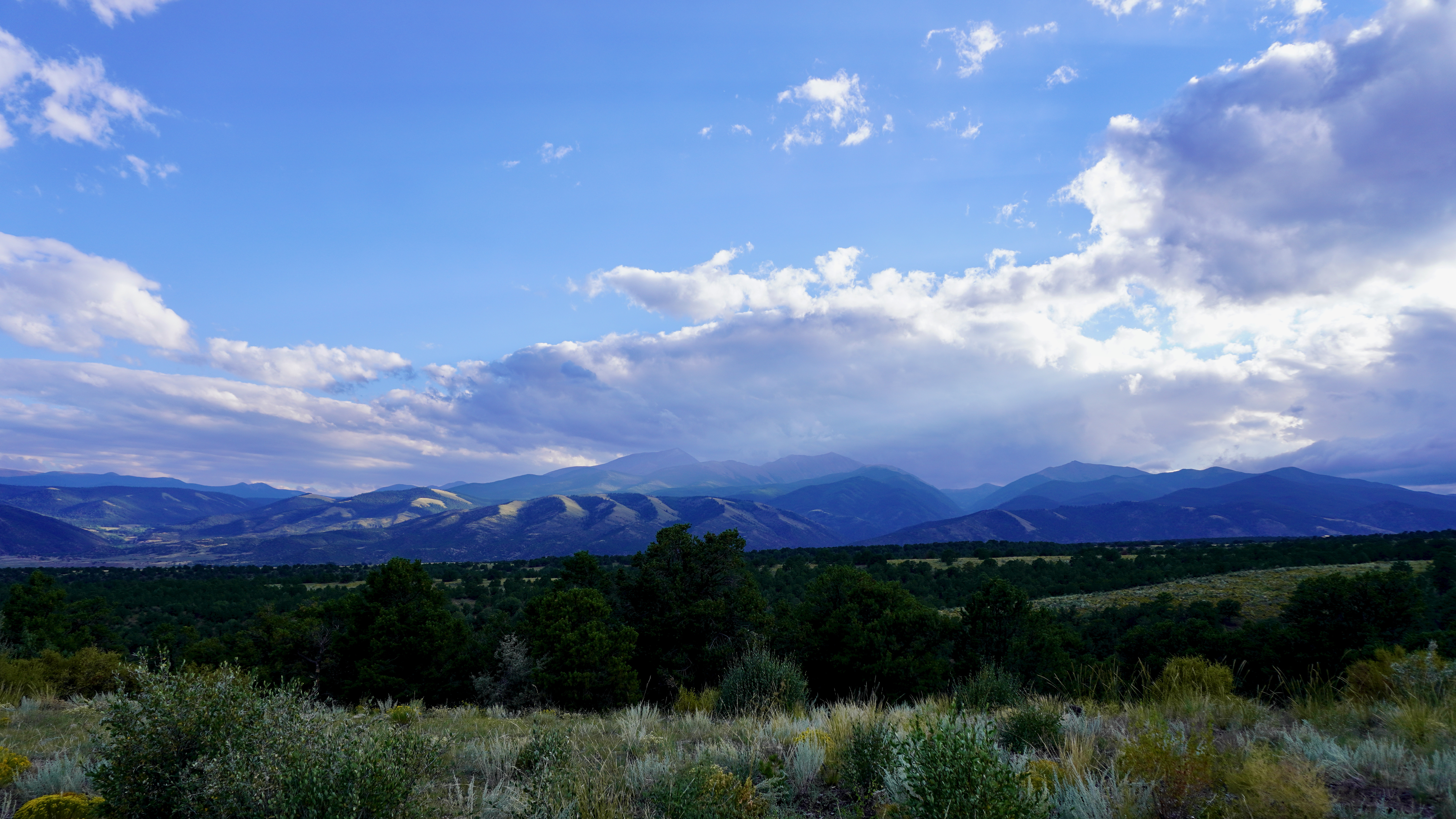 mountains in the background with clouds above from shavano wildlife management area