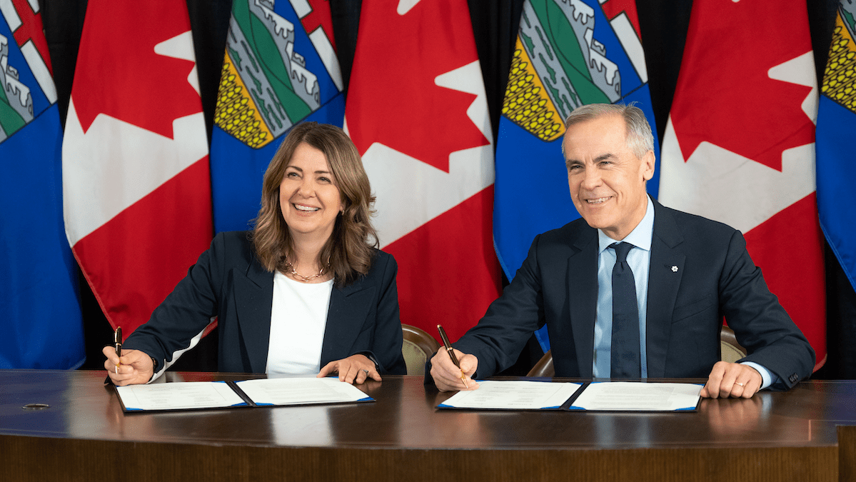 Danielle Smith and Mark Carney signing a memorandum of understanding between their two governments. Credit: Alberta Newsroom