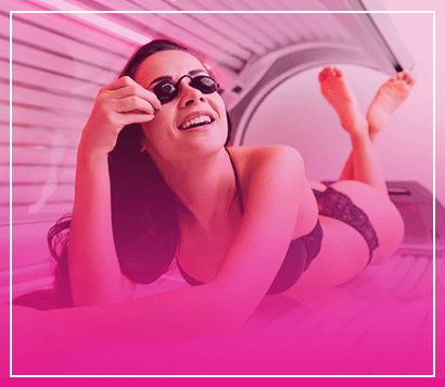 woman smiling while tanning inside a sunbed with pink overlay at Cancun Tan