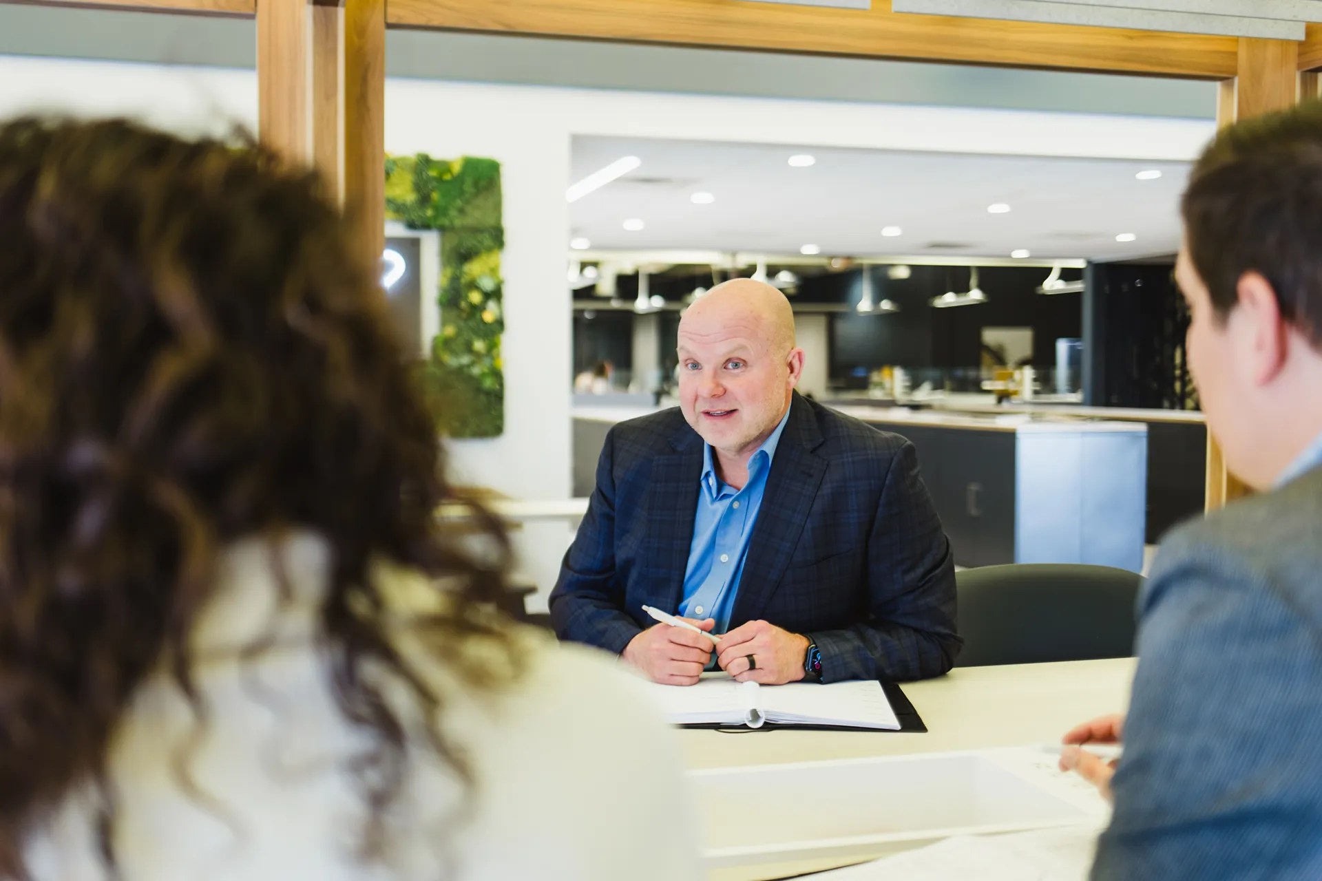 Sales team and clients discussing business office furniture solutions in a collaborative conference setting.