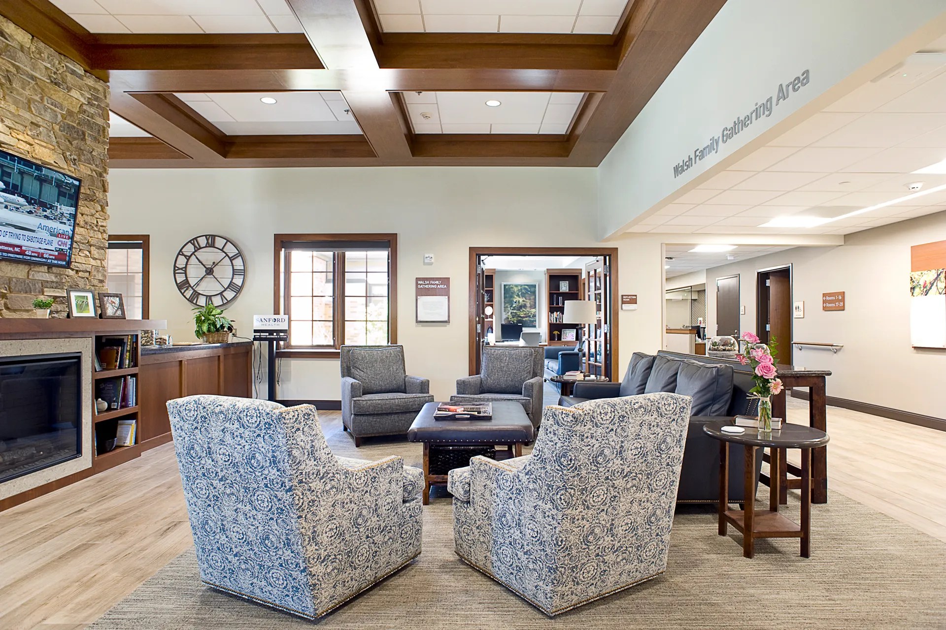 Welcoming lobby of a long-term care facility with wood-look flooring, stone accents, and comfortable seating for guests.