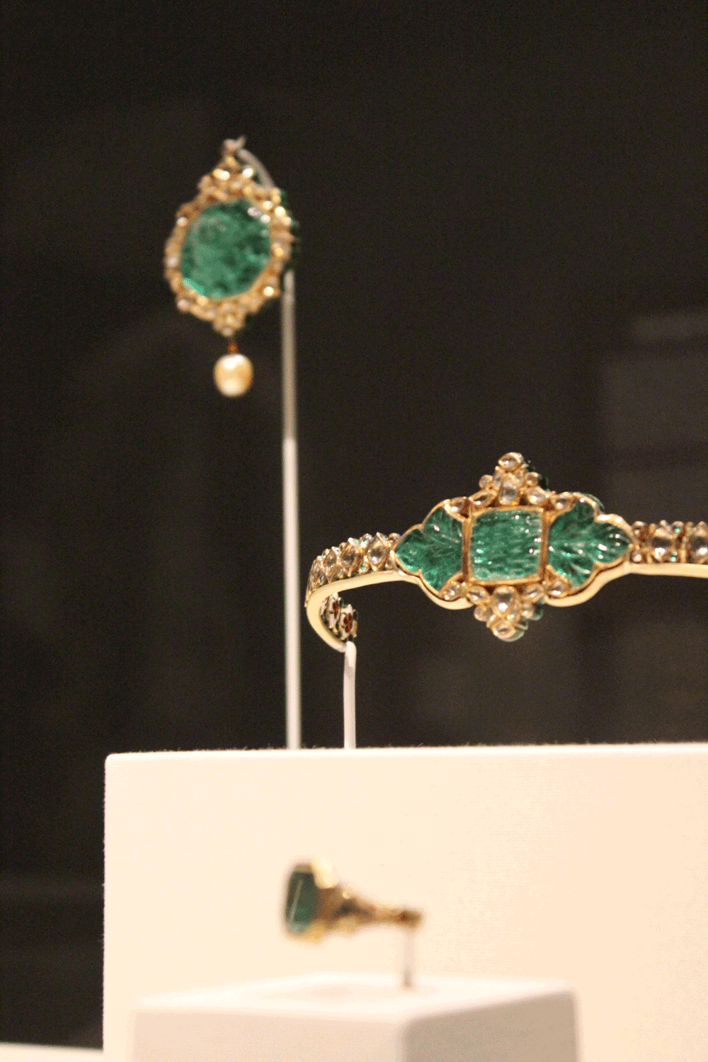 A pendant, bracelet and ring of gold, emerald, diamonds, enamel and pearls, all from the 1700s, on display at “Art and Stories from Mughal India.” PHOTO | Michael C. Butz
