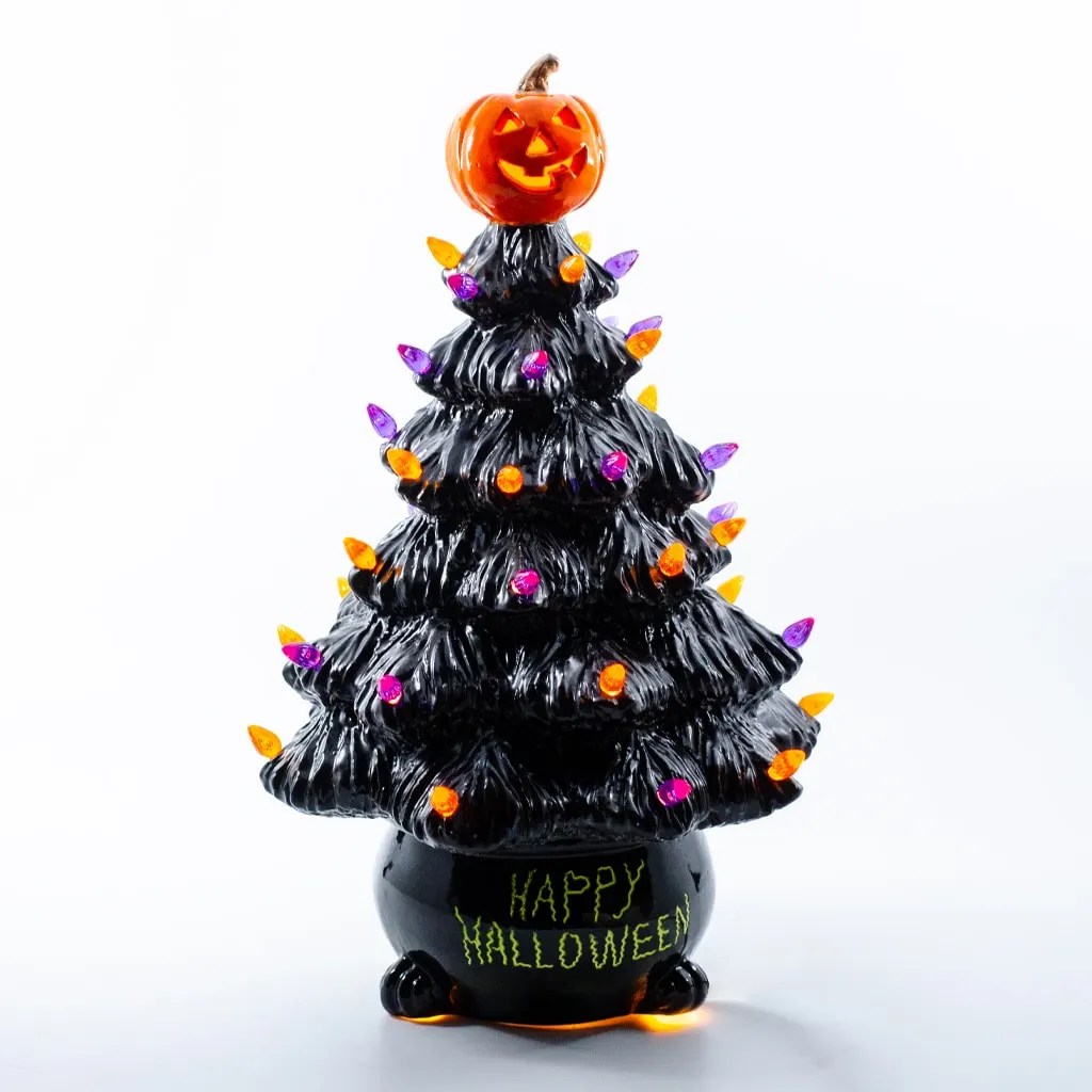 Black Halloween tree with a jack-o'-lantern topper and multicolored lights, set in a glossy black pot reading 'Happy Halloween' in lime green.