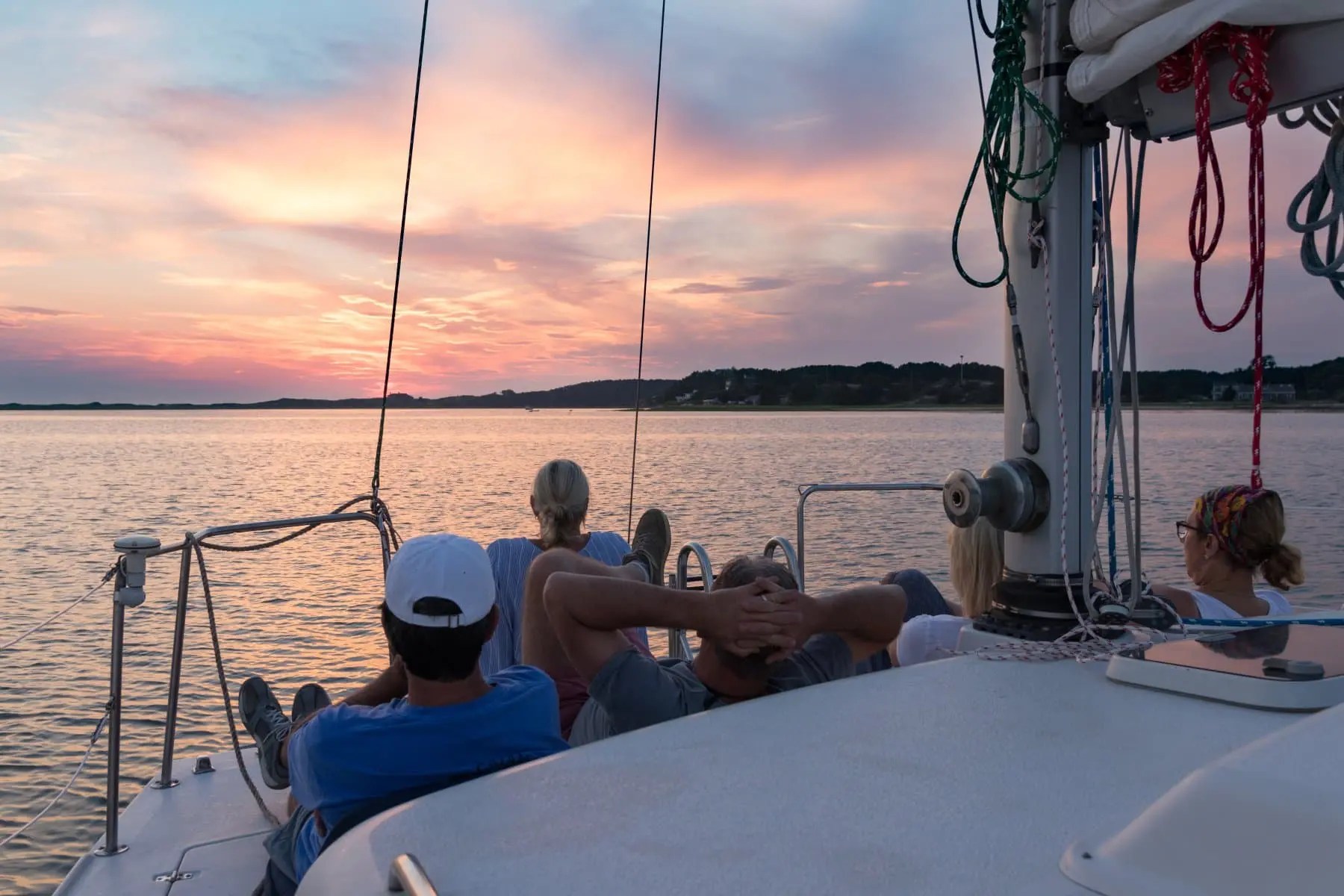 Guests relaxing on deck during a sunset sail on Cape Cod Bay