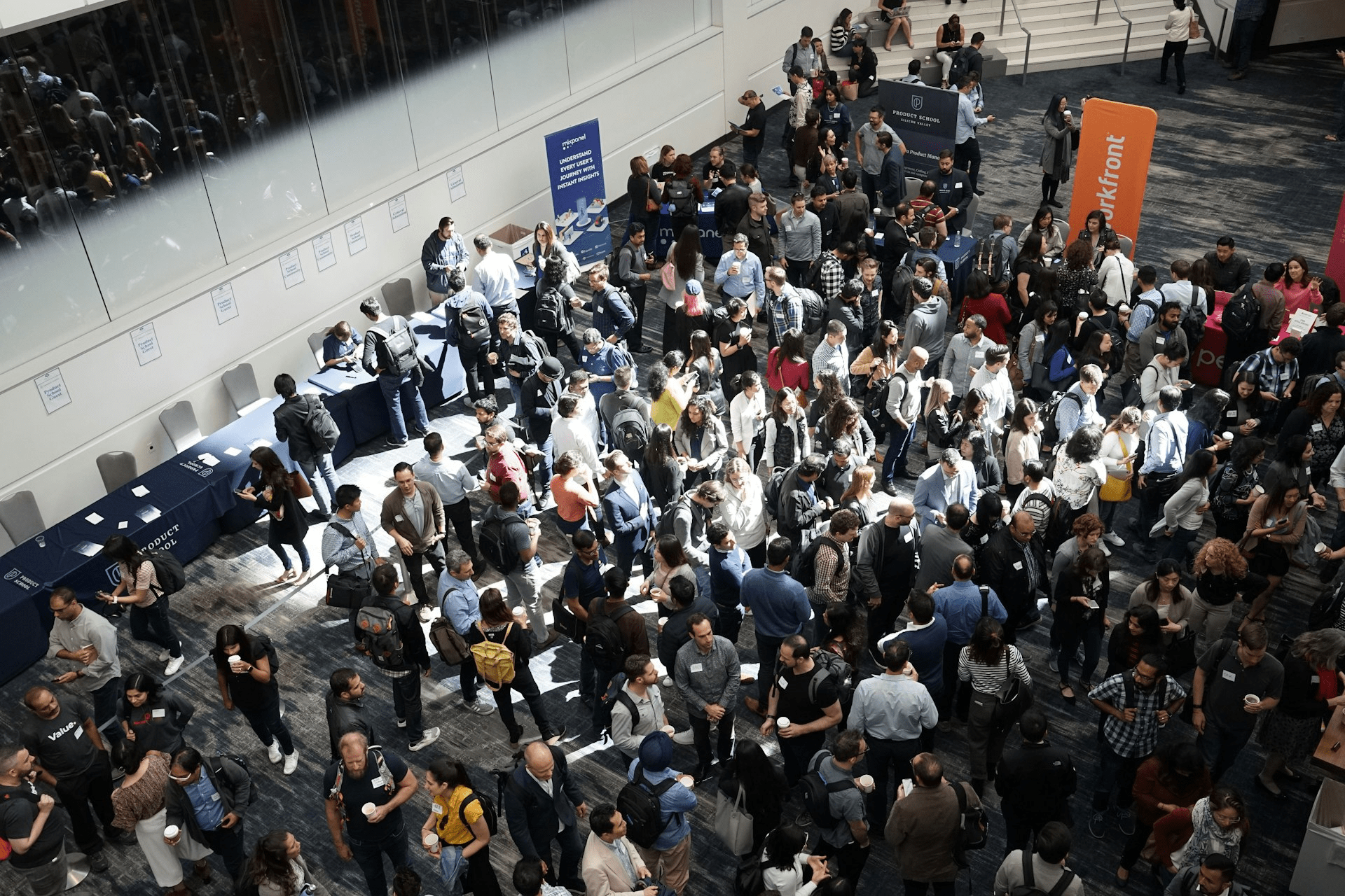 Professionals mingling at a crowded networking event in a building lobby