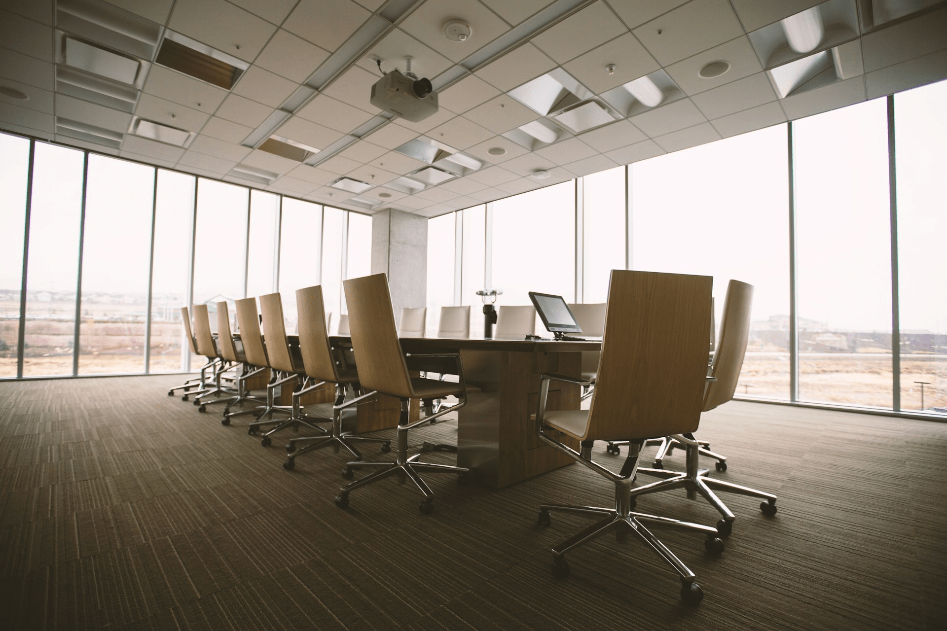 Empty oval conference table and chairs in a meeting room