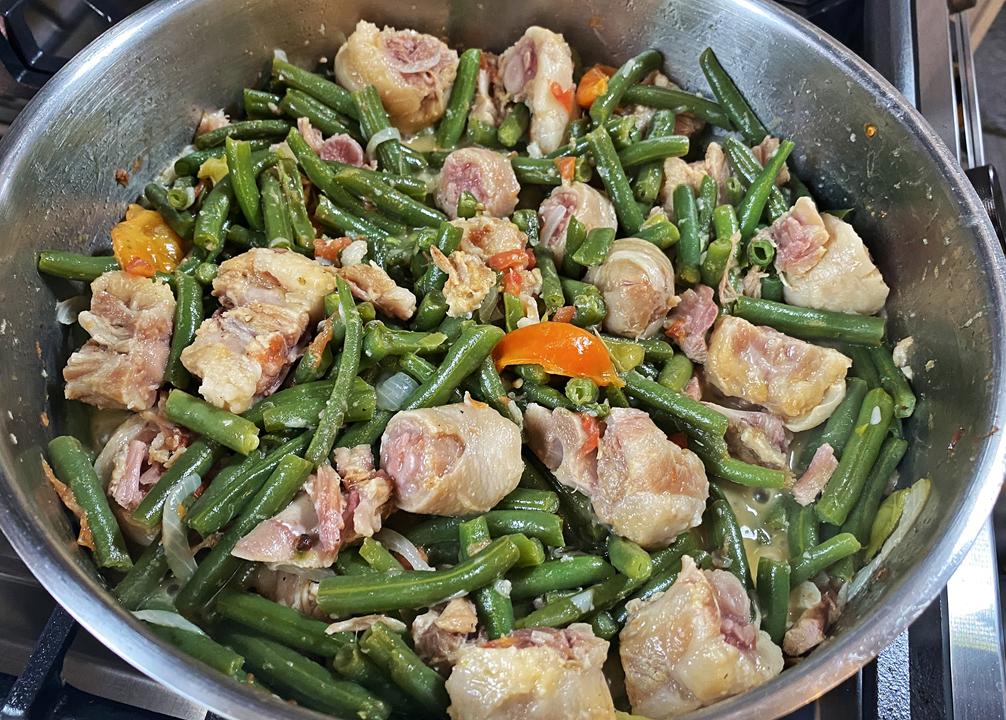 Salted pigtails with string beans in coconut milk in a large silver dish