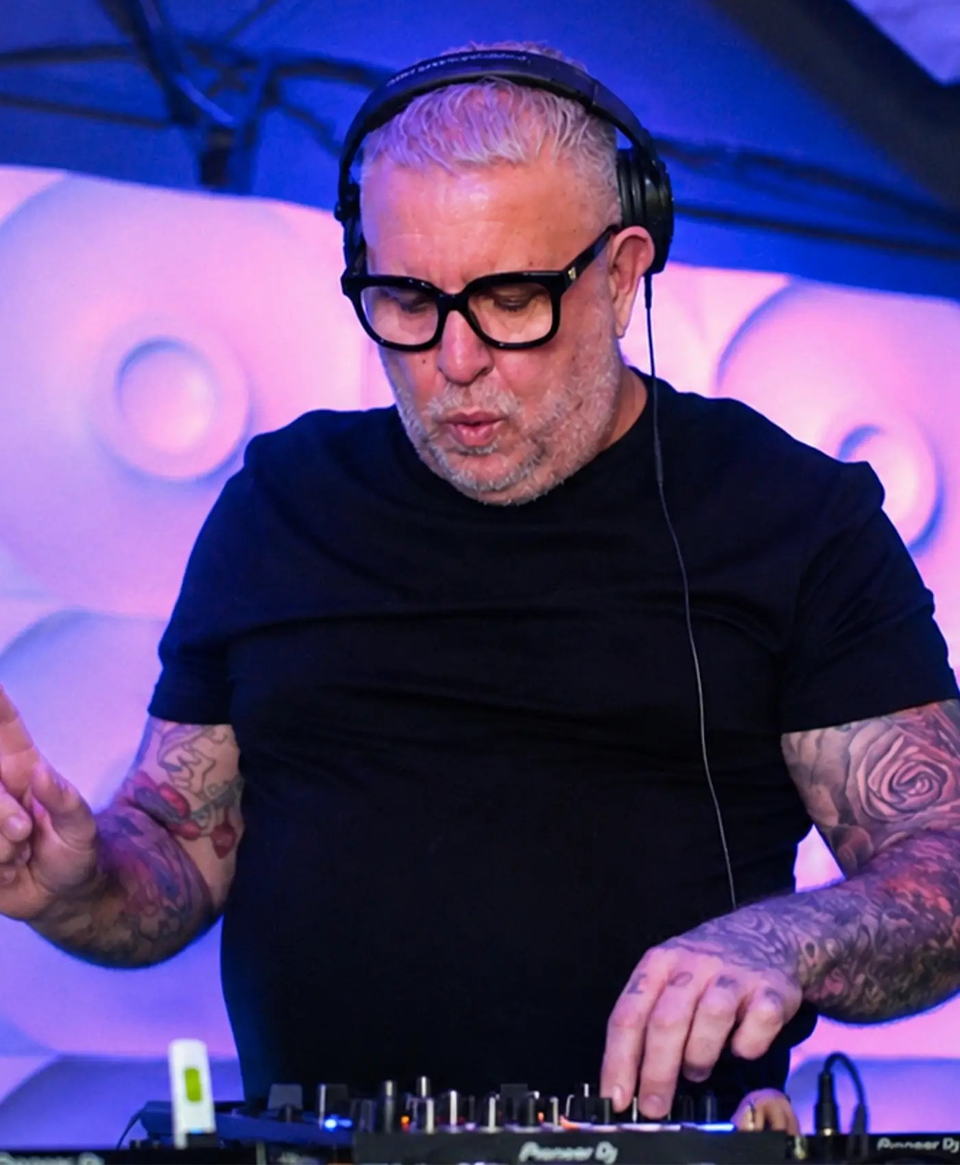 Carl Mitchell DJ performing at an event in Sutton Coldfield wearing headphones and mixing music.