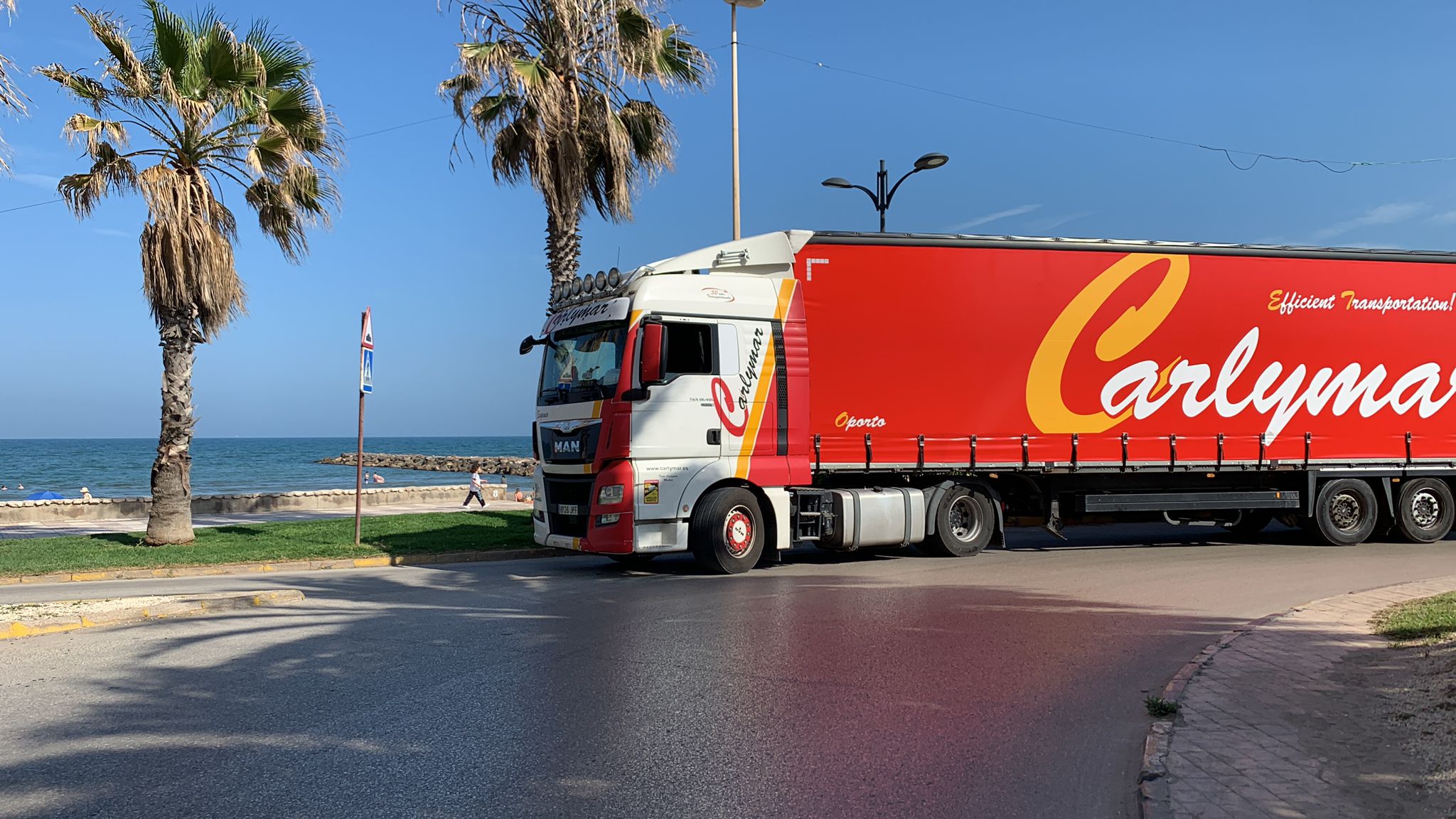 Camión de transporte nacional de mercancías con playa al fondo