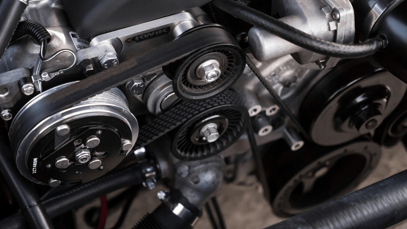 Close-up of classic V8 engine bay belts pulleys and harmonic balancer area