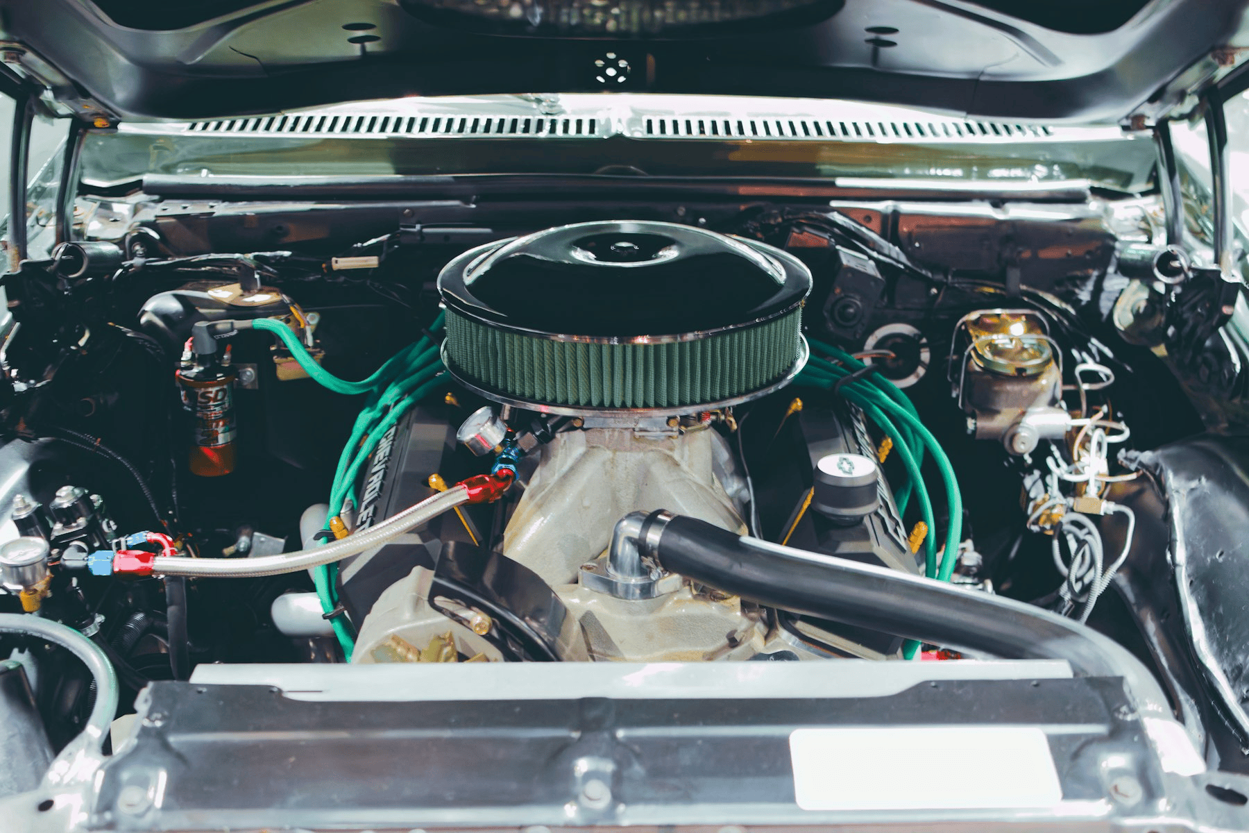 Close-up of a classic carbureted V8 engine in a restored engine bay