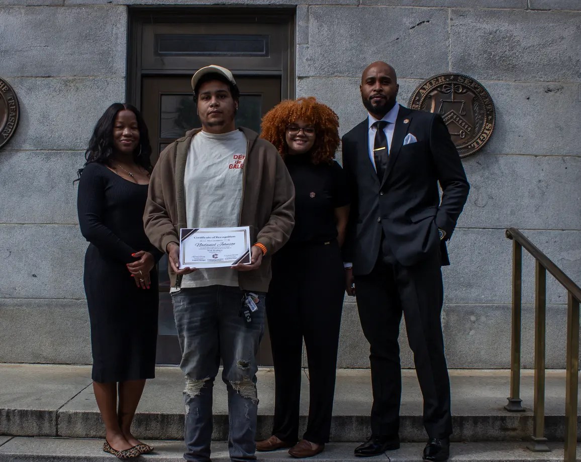 person standing with certificate in a group